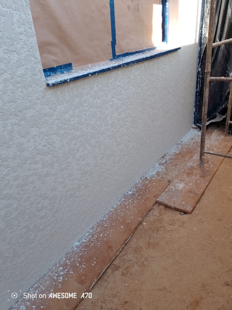 Proteção rigorosa de janelas e piso com fita azul e papel pardo na aplicação de textura