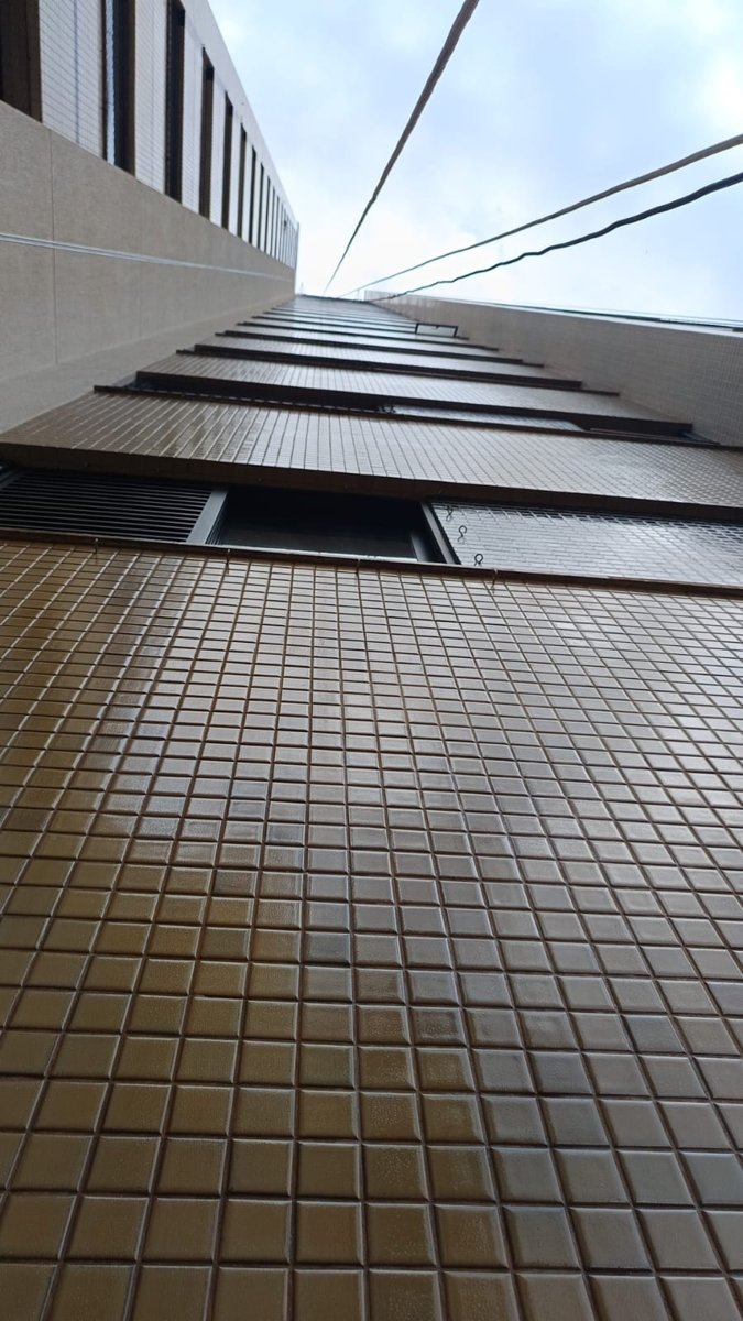 Pintor suspenso no andaime organizando cordas e equipamentos de segurança